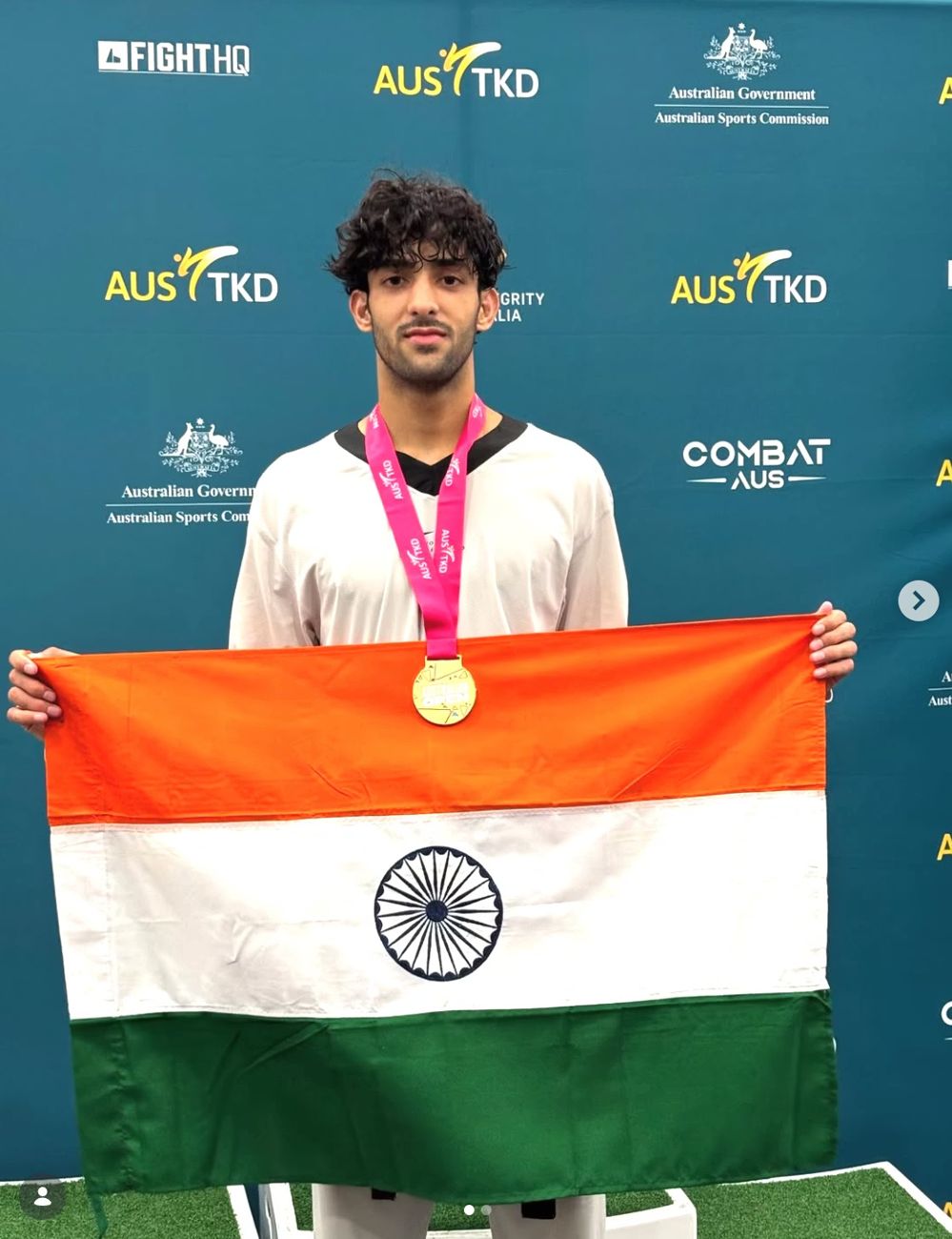 Taekwondo athlete Nitesh Singh holding the Indian flag with a gold medal